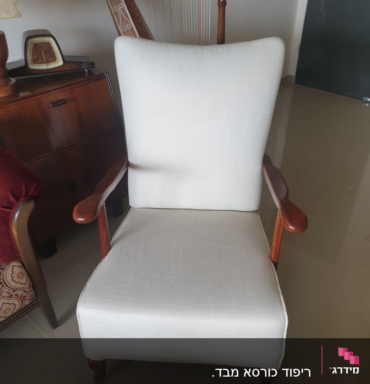 כורסה מרופדת בבד בהיר עם ידיות עץ